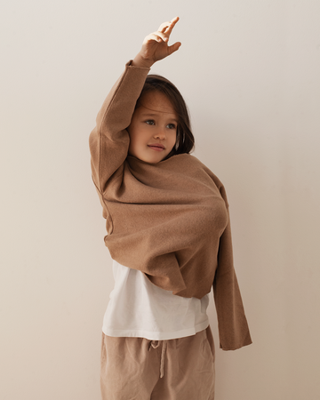 girl wearing caramel blouse, white tee and corduroy pant